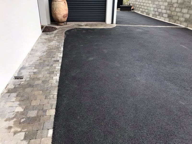 Enrobé noir avec pourtour de maison en pavés gris